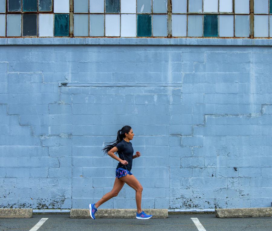Runner passing a blue wall