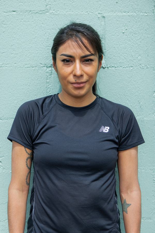 Portrait of Brenda Martinez against a mint wall