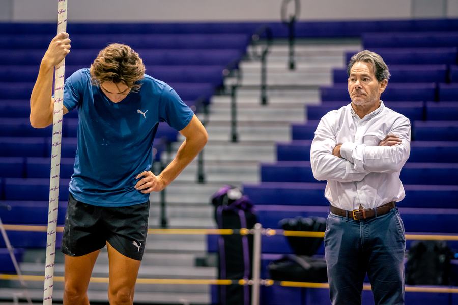 Resting on the pole with his coach