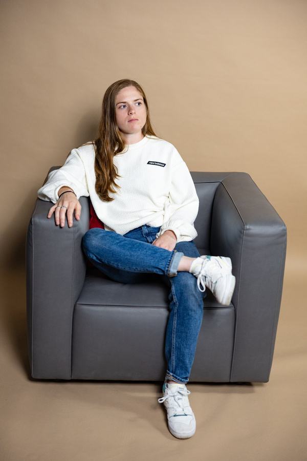 In the chair, jeans and white