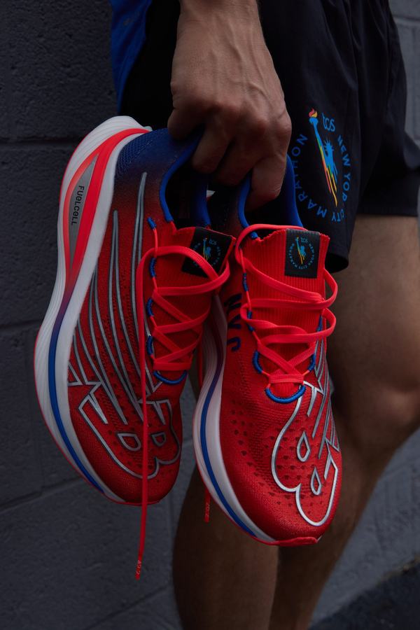 Red and blue NYC Marathon race shoes held in hand