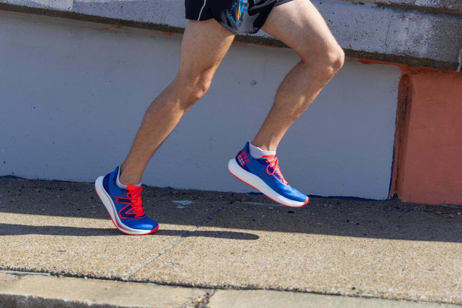 Runner in motion beside brick