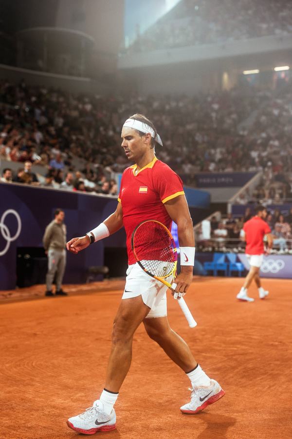 Nadal walking the baseline, Alcaraz behind