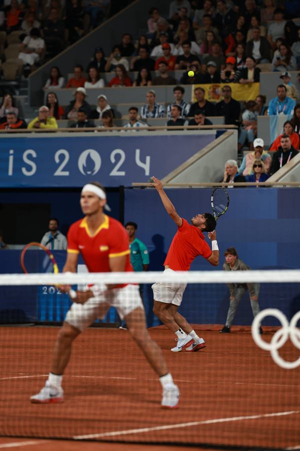 Nadal serving in front of the Paris 2024 boards