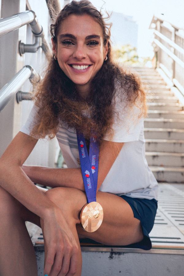Smiling on the steps, medal round her neck