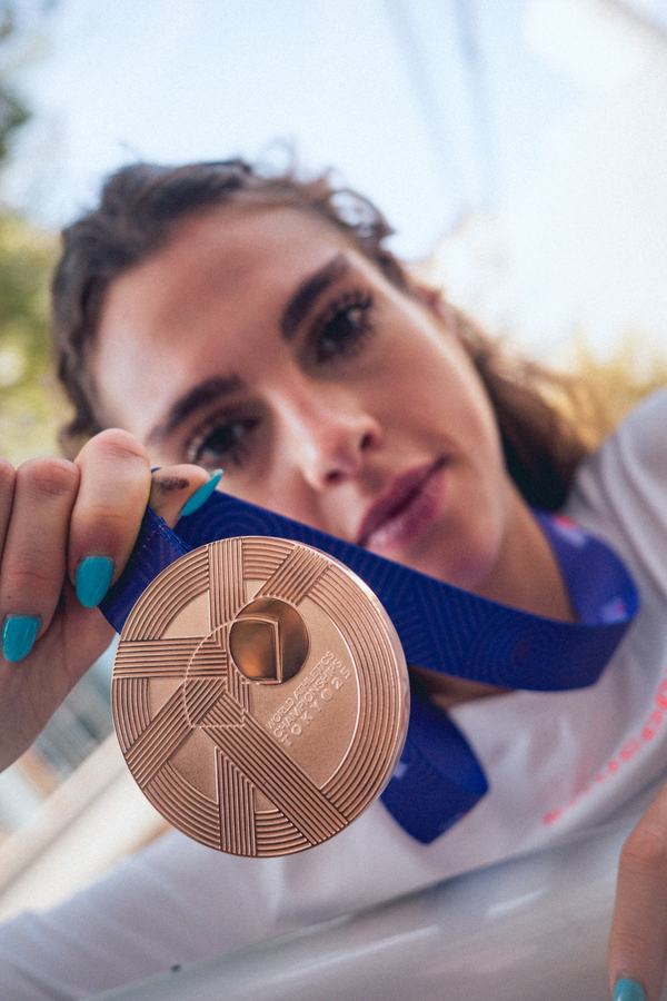 Holding the medal up to the camera
