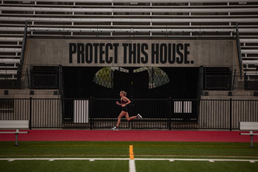 A runner alone on the track beneath Protect This House